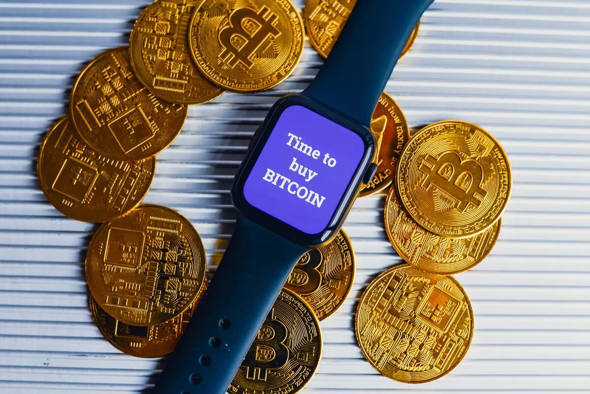 Apple Watch and golden coins with Bitcoin symbol