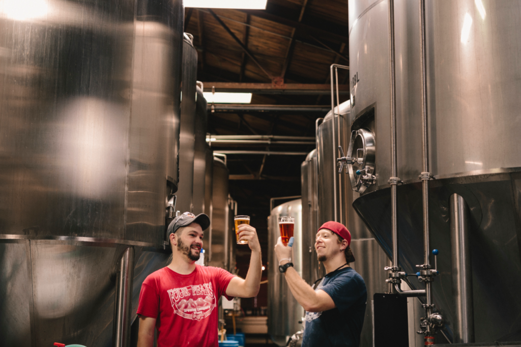 Two guys at the brewery with glasses of beer