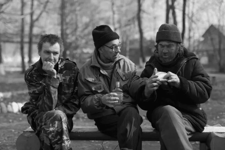 Three Russian bums drinking vodka in the park