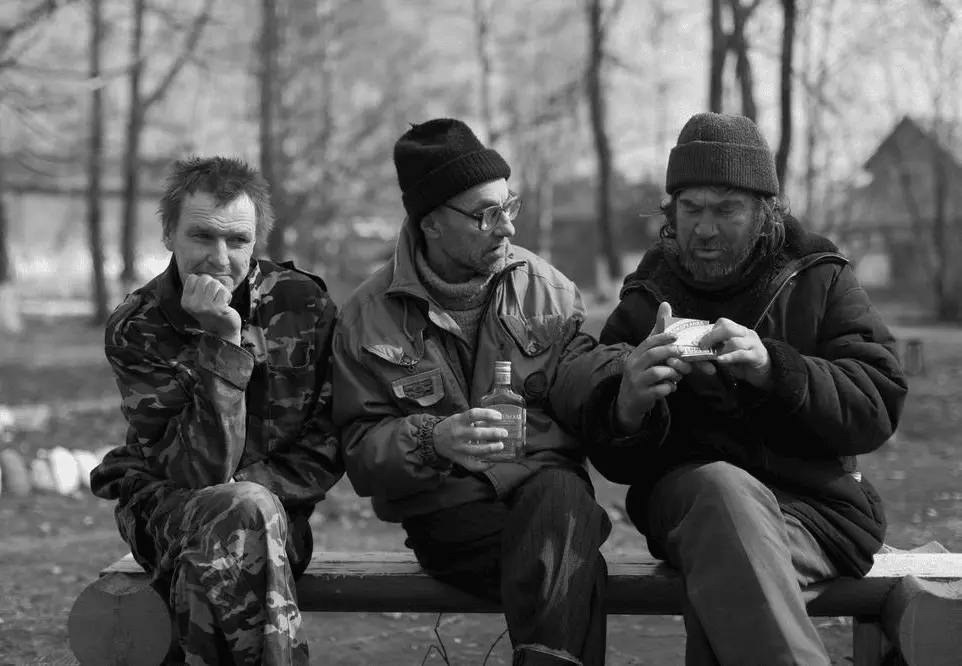 Three Russian bums drinking vodka in the park