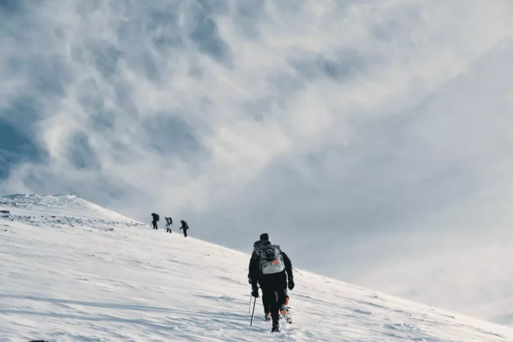 People are climbing the hill covered by snow