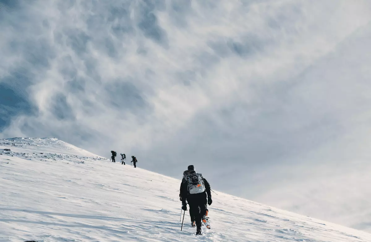 People are climbing the hill covered by snow