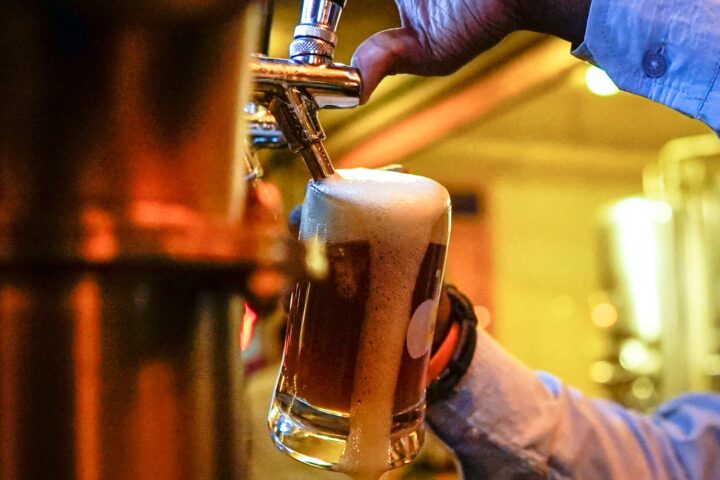 The bartender pouring the beer.