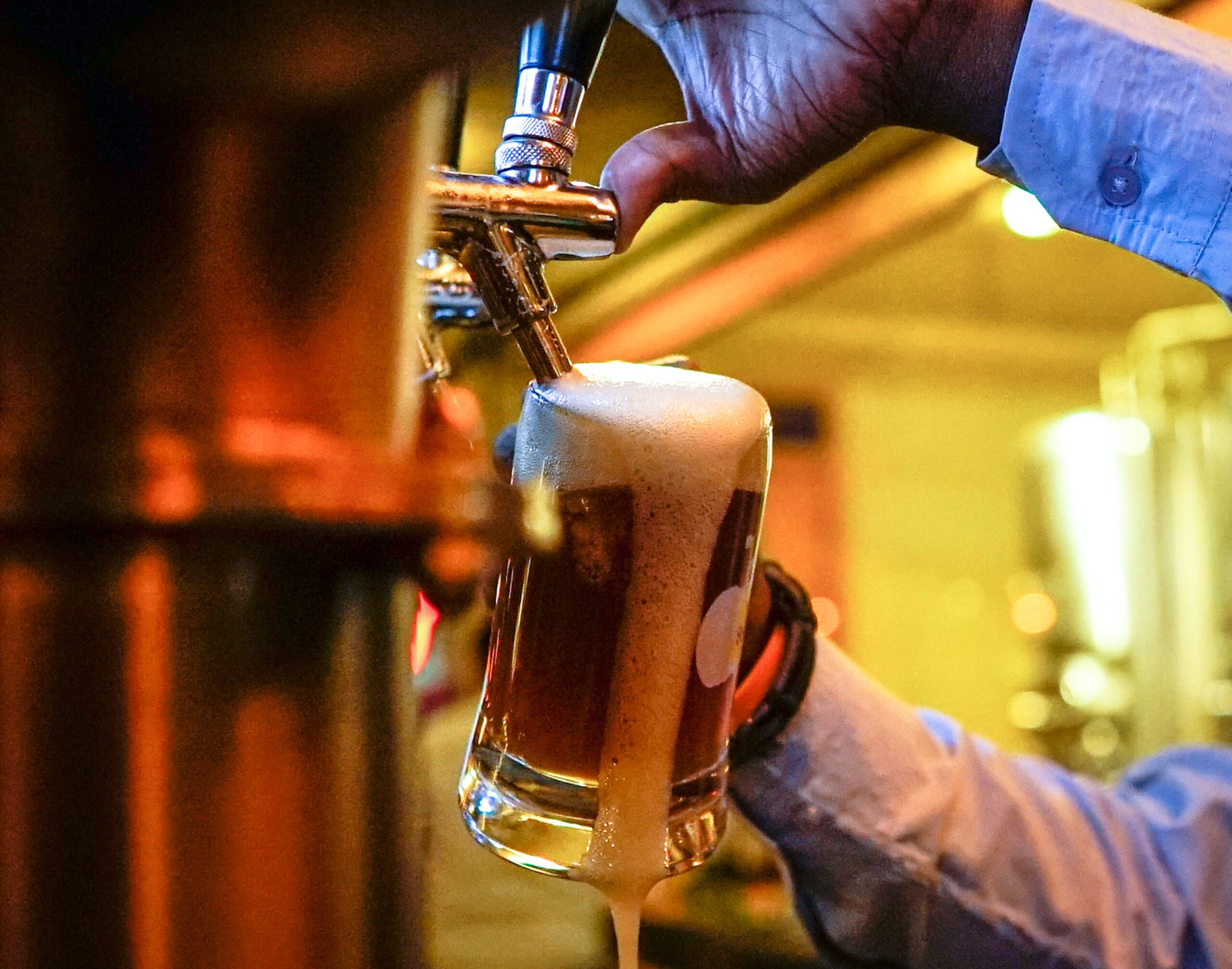 The bartender pouring the beer.