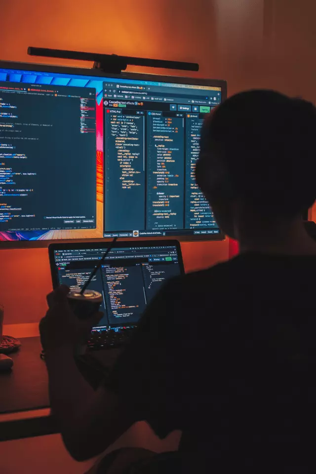 The Developer in front of the screens with code