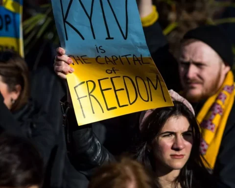 A girl with Ukrainian flag at the protest in Manchester