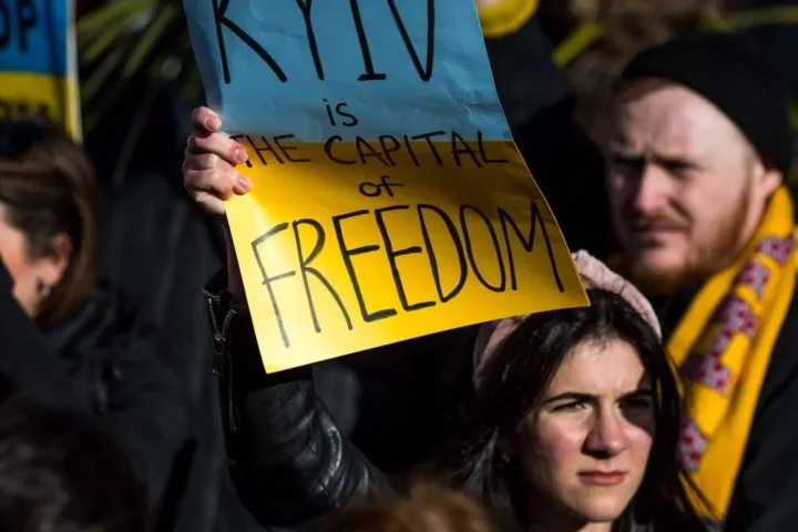 A girl with Ukrainian flag at the protest in Manchester