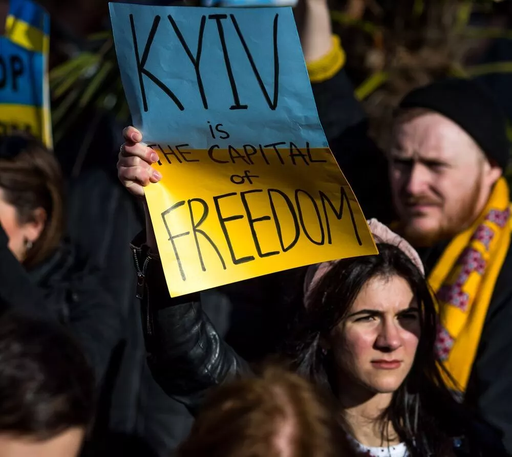 A girl with Ukrainian flag at the protest in Manchester