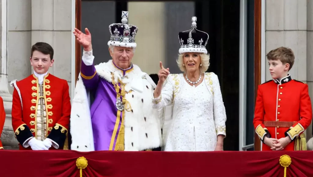 King Charles III and Queen Consort Camilla waving hands in front of people